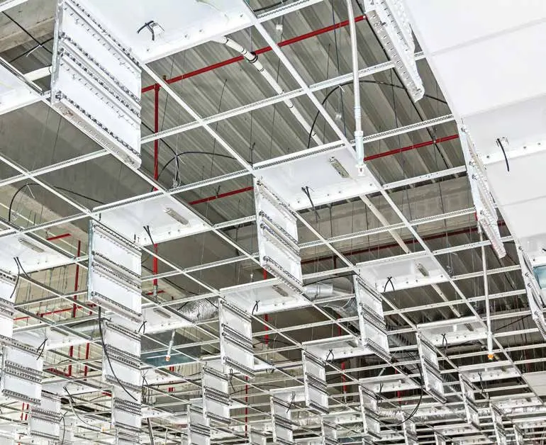 Suspended ceiling grid installed below ductwork and sprinkler pipes